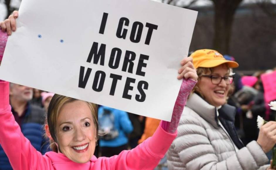 Una manifestante se burla de Trump al indicar que Hillary Clinton obtuvo más votos que él en las elecciones.